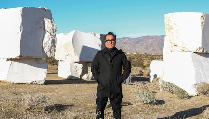 Mexican artist Jose Davila poses in front of his piece The Act of Being Together, made of stacked 16-ton marble boulders ahead of the Desert X exhibit in Californias Coachella Valley. — AFP