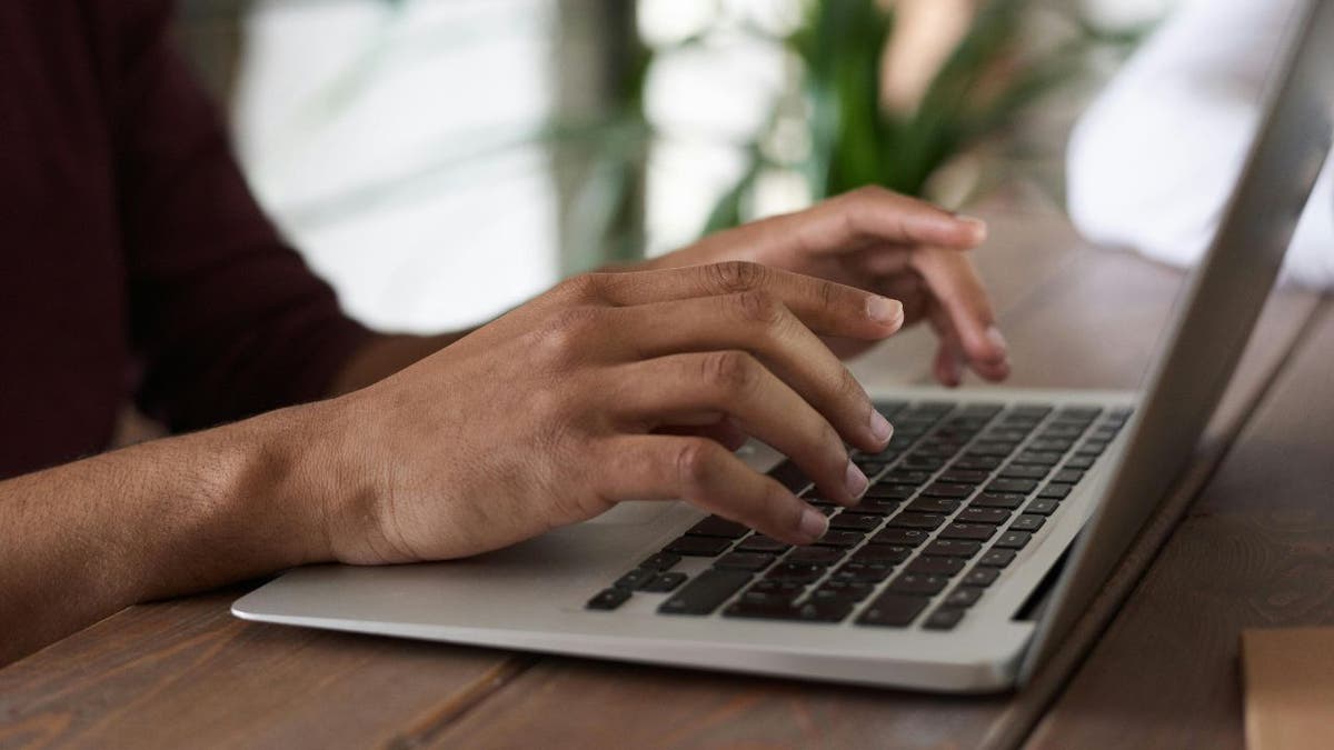 man types on laptop